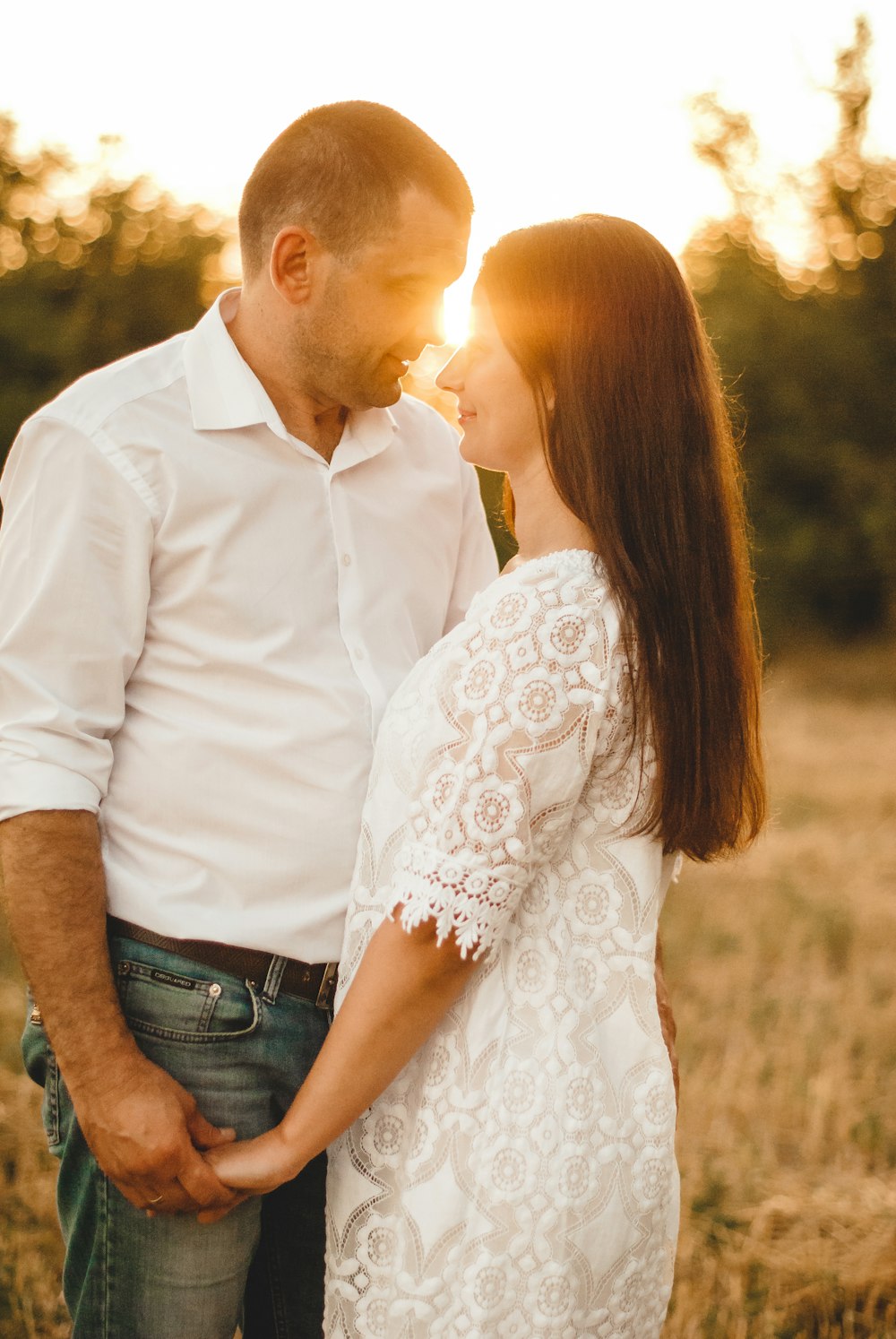 man in white dress shirt and woman in white floral dress