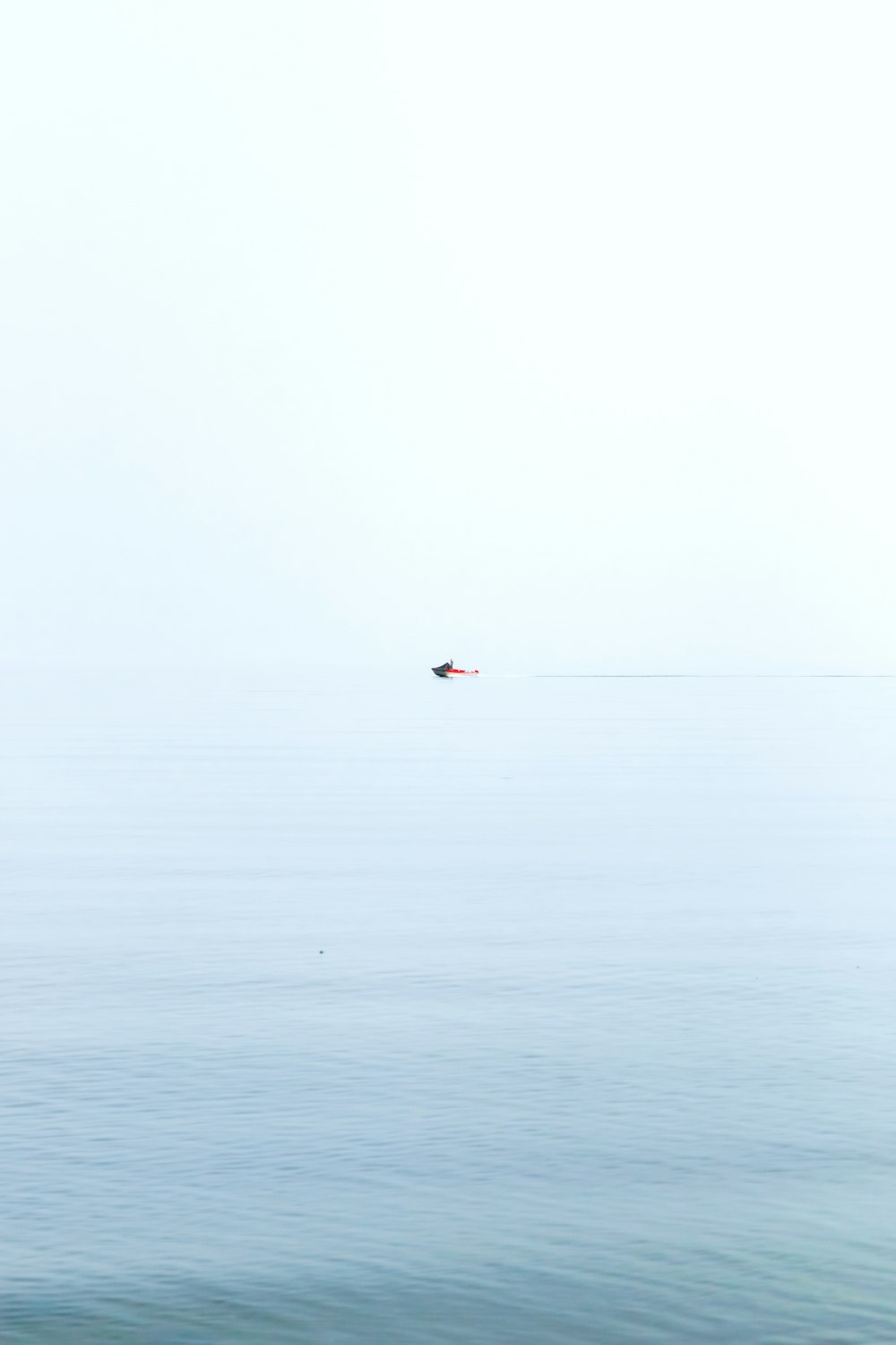 person in red shirt surfing on sea during daytime