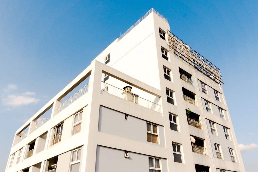 Weißes Betongebäude unter blauem Himmel tagsüber