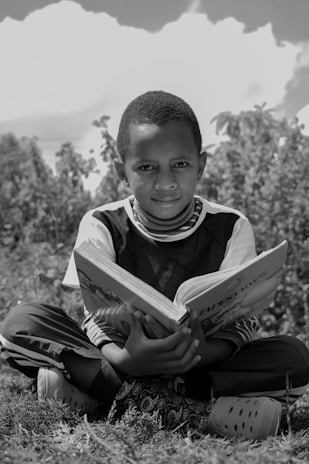 boy in black and white crew neck shirt holding book