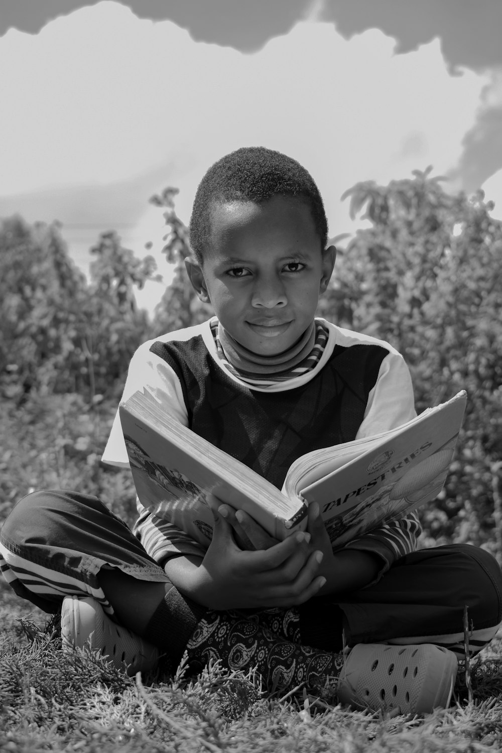 boy in black and white crew neck shirt holding book