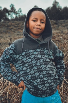 A young man confidently wearing a stylish hoodie outdoors.