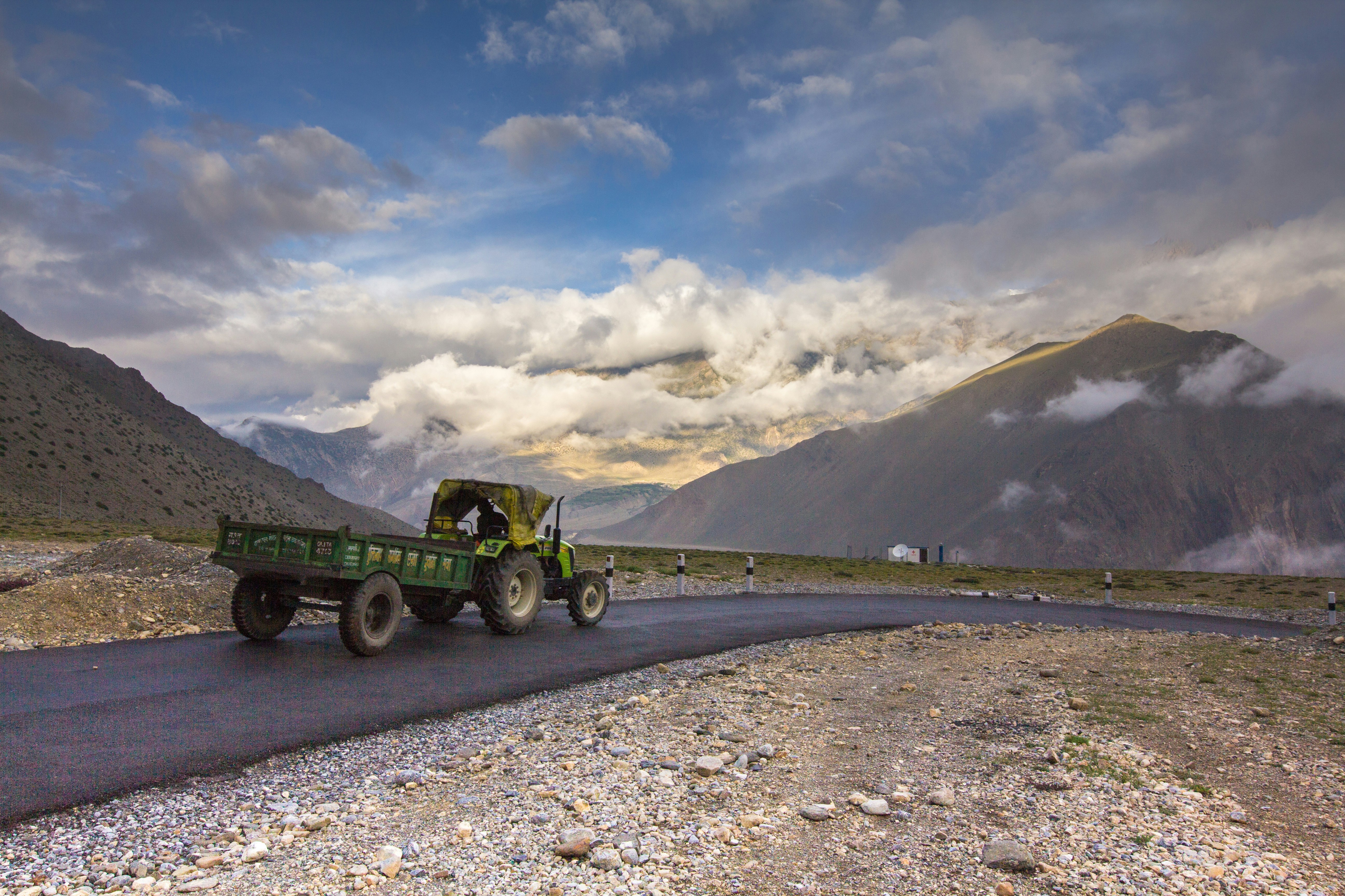 green utility trailer on gray dirt road during daytime, Traveling through the infinity 