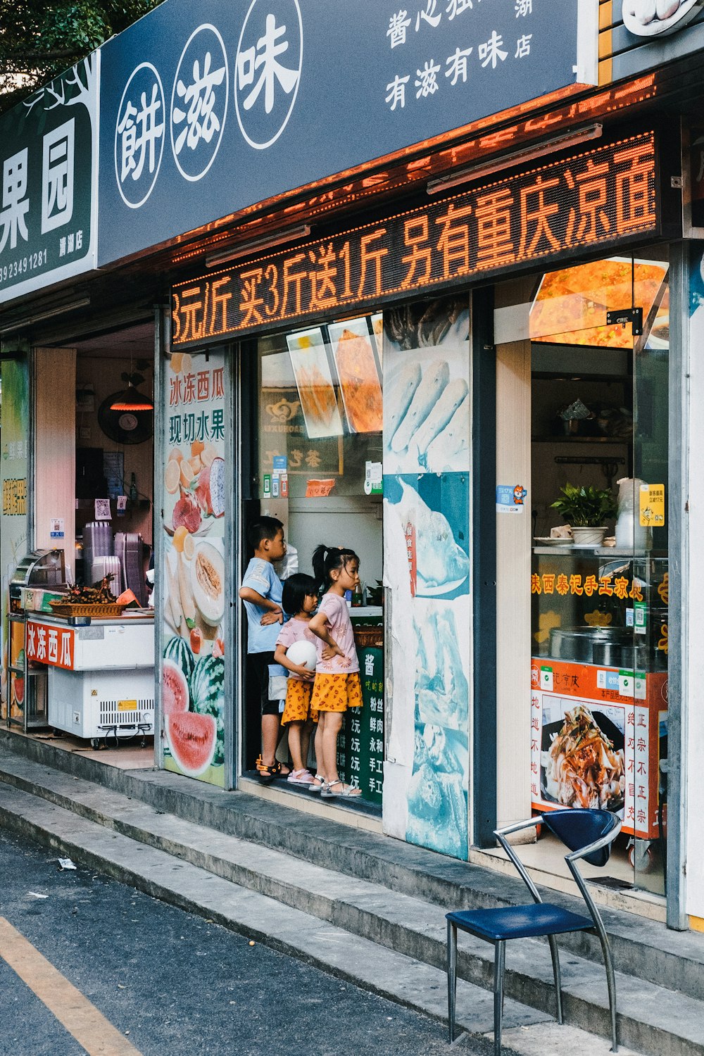 woman in white and orange floral dress standing beside store