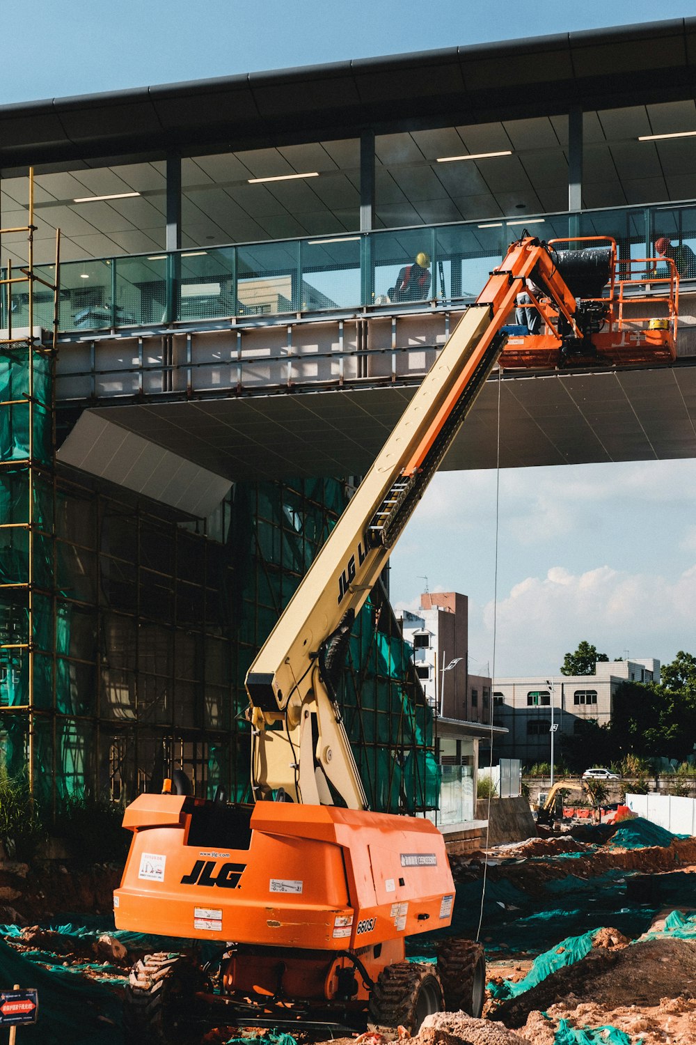 orange and black crane near building during daytime