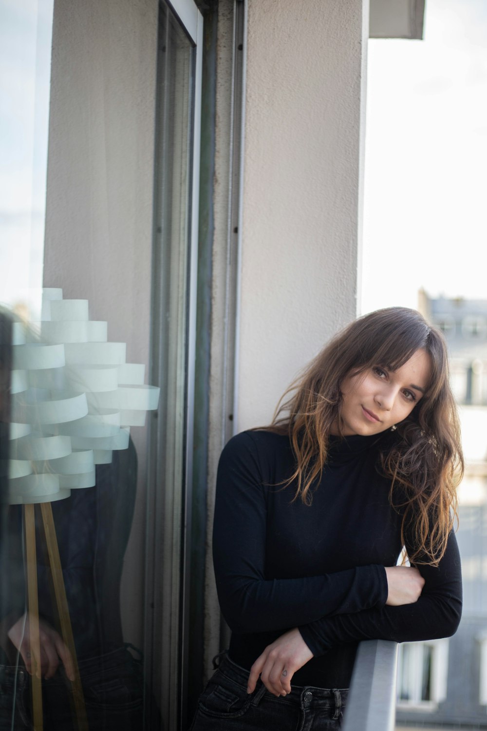 woman in black long sleeve shirt sitting beside glass window