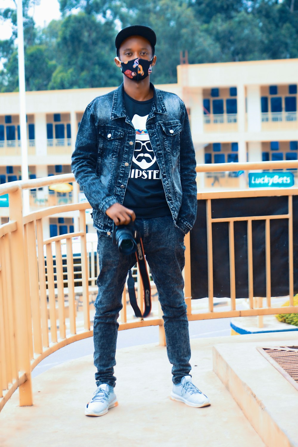 Man in blue denim jacket and black pants standing on white wooden bench  during daytime photo – Free Butare Image on Unsplash