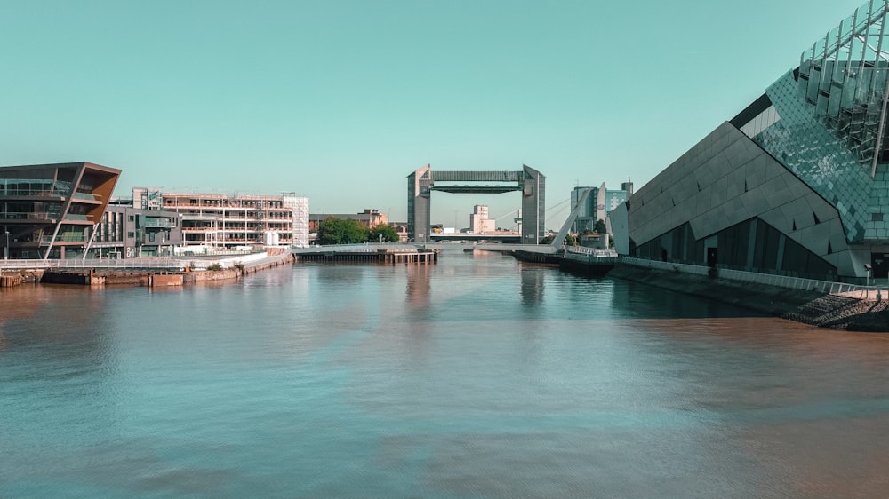 Weißes und graues Betongebäude in der Nähe von Gewässern tagsüber