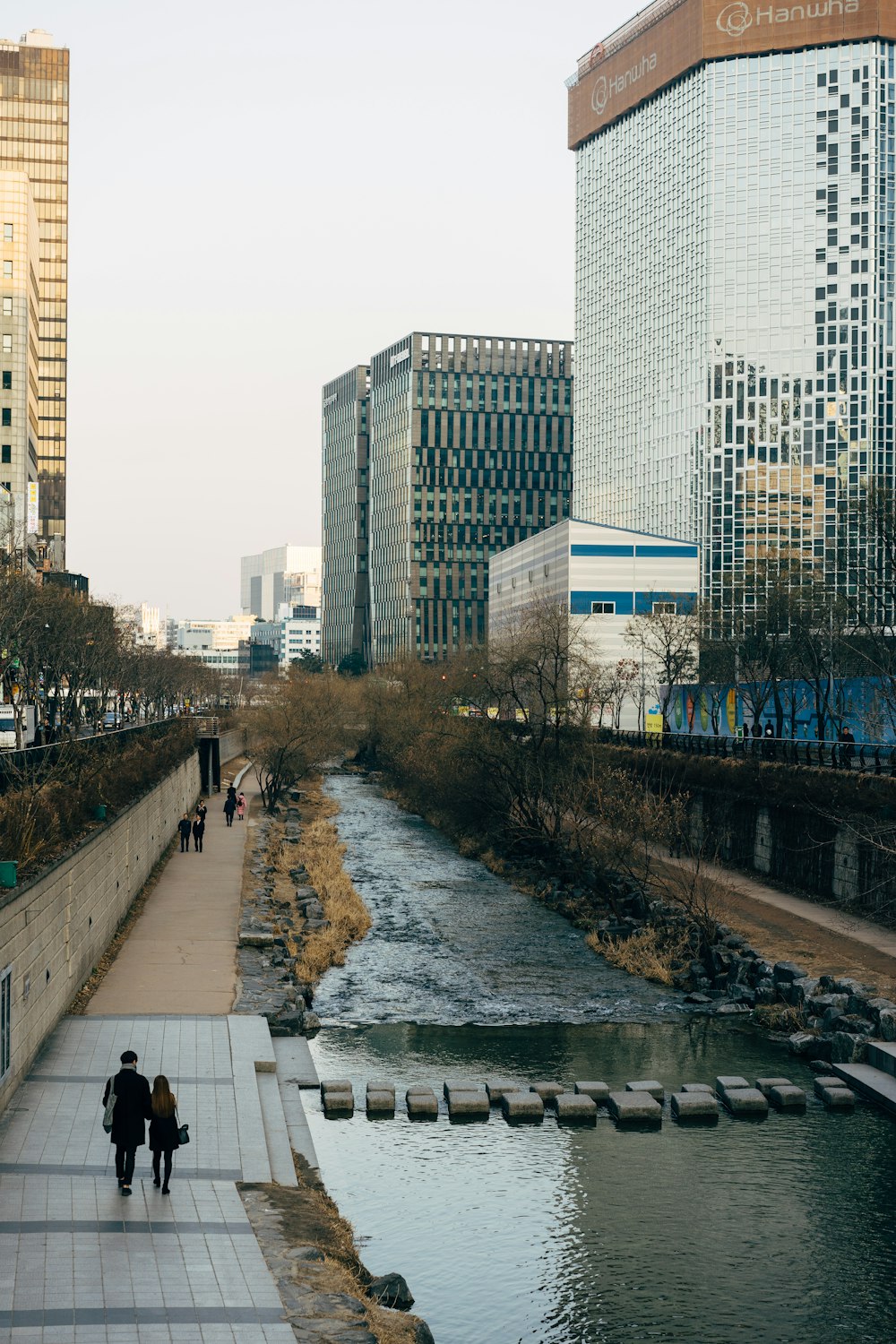 People Walking On Sidewalk Near High Rise Buildings During Daytime