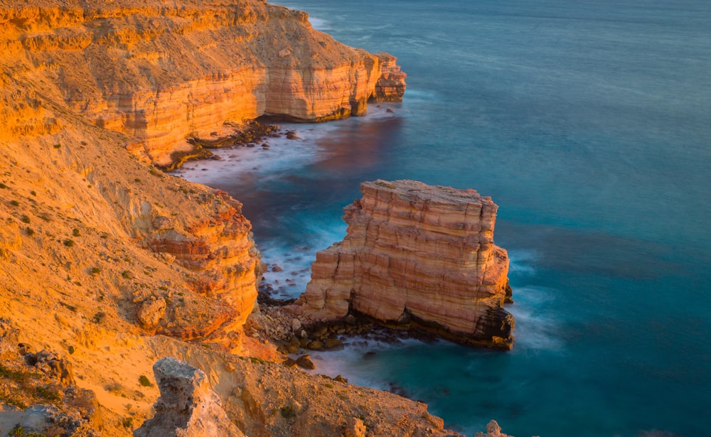 brown rock formation on blue sea water during daytime