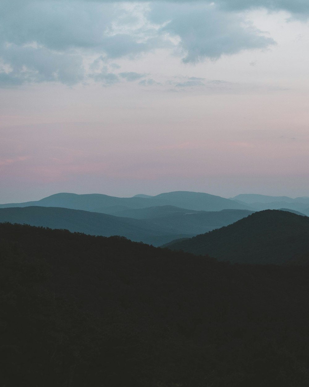 silhouette of mountains under white clouds during daytime