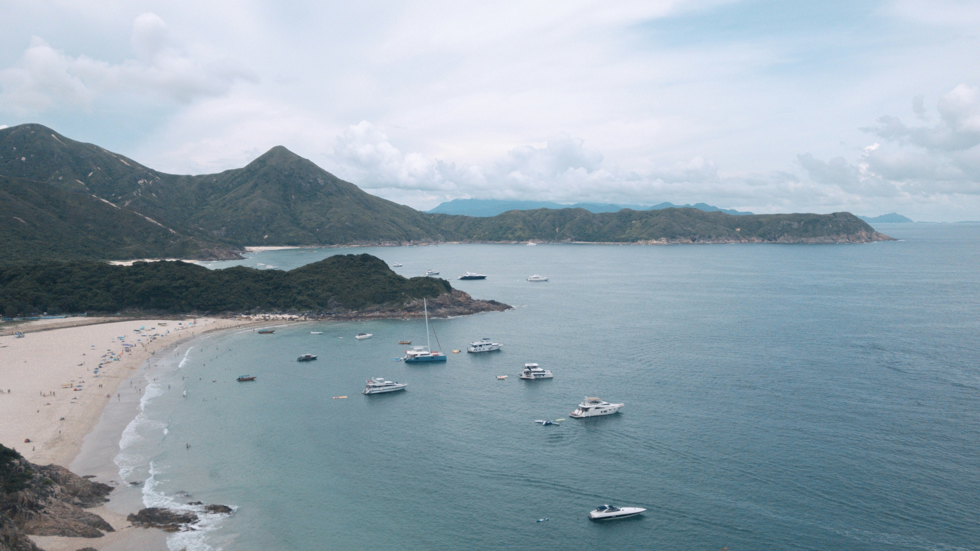 boats on sea near mountain during daytime