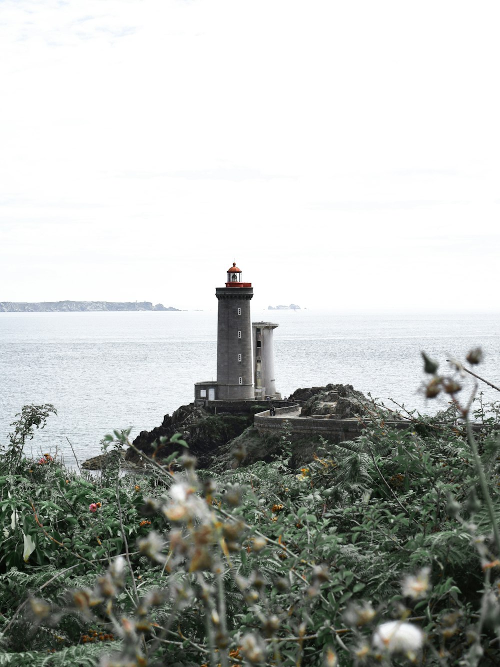 white lighthouse near body of water during daytime