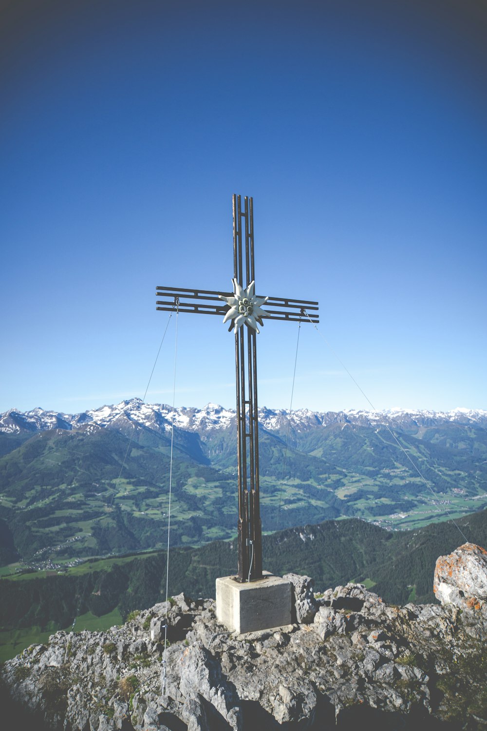 cruz preta no topo da montanha durante o dia