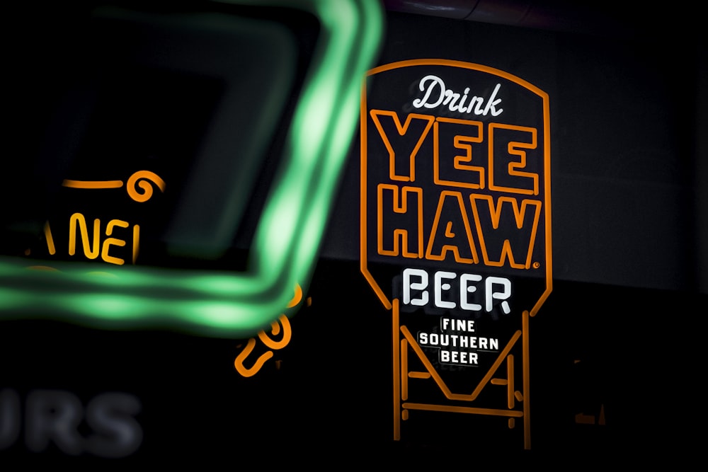 a neon sign that says yeeee haw beer next to a neon sign