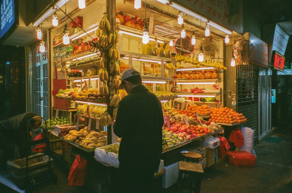 man in black jacket standing in front of food display counter