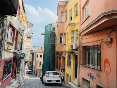 A sunny street in Marseille with various homes undergoing different stages of renovation.