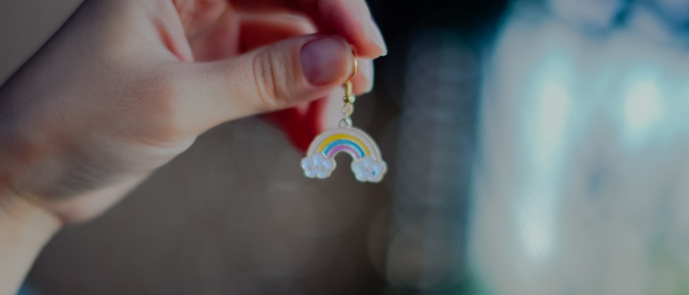 person holding silver and pink accessory