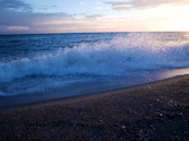 Waves crashing on the beach at sunset, reflecting the brand's surf-inspired spirit.
