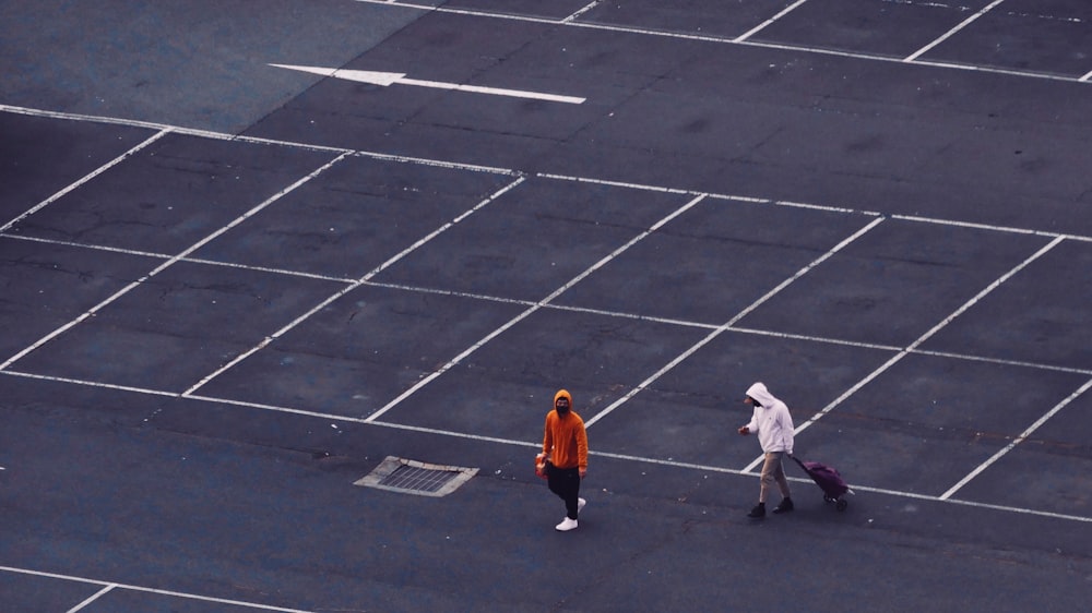 2 women walking on gray concrete pavement