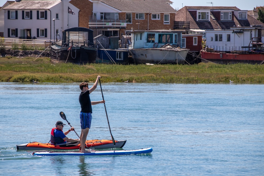 Hombre con camisa azul montando en kayak azul durante el día