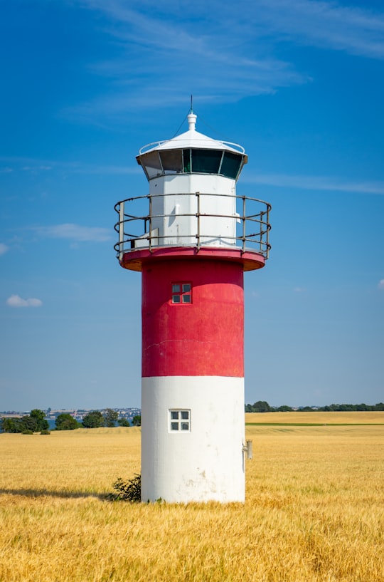 red and white lighthouse under blue sky during daytime in Hven Sweden
