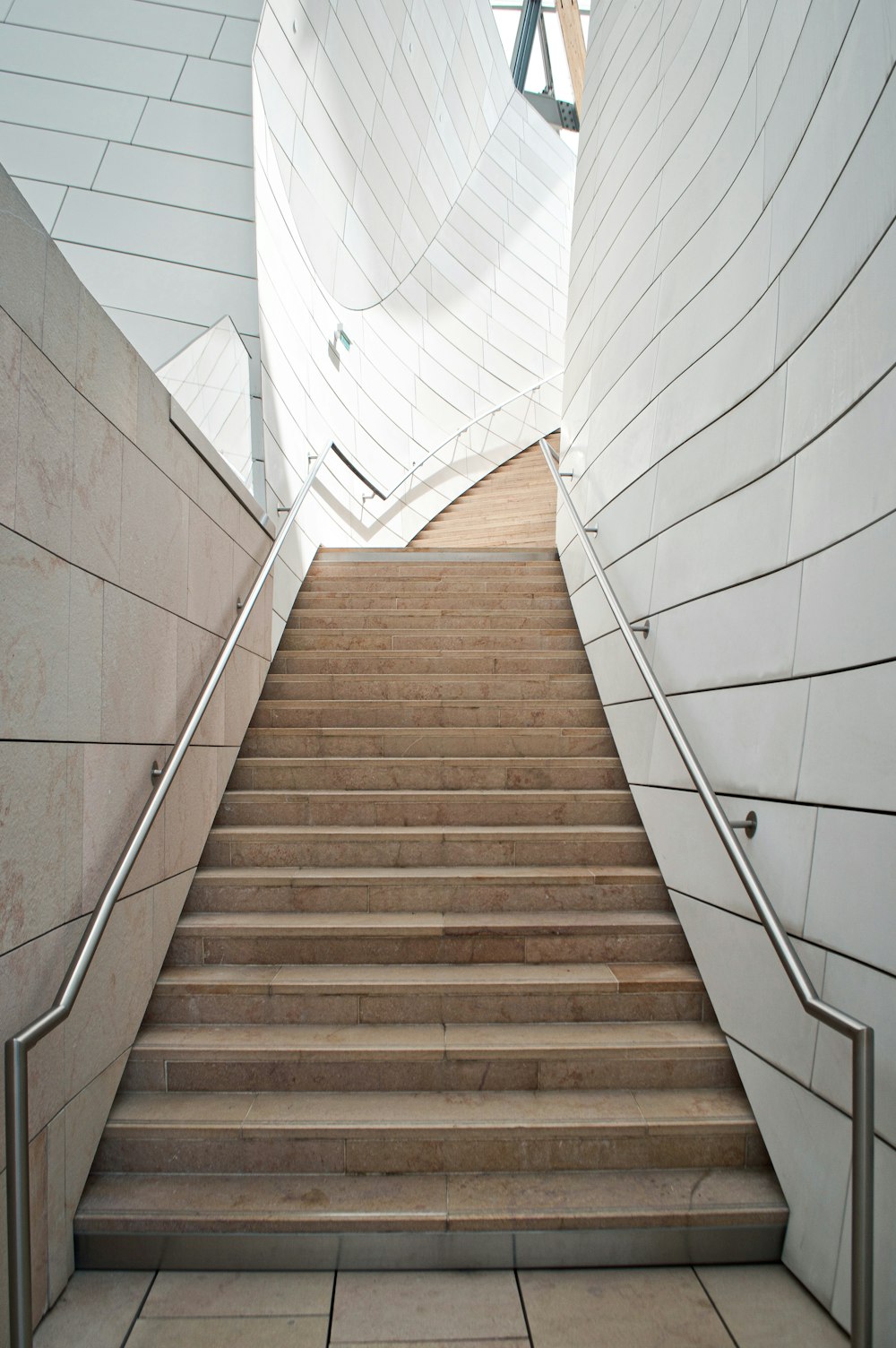 brown wooden staircase with white metal railings