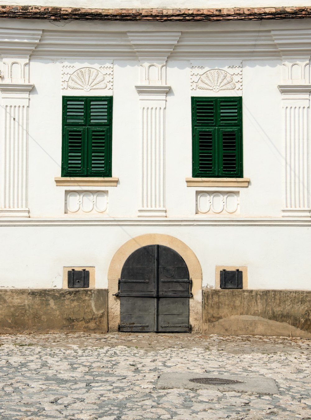 black wooden door on white concrete building