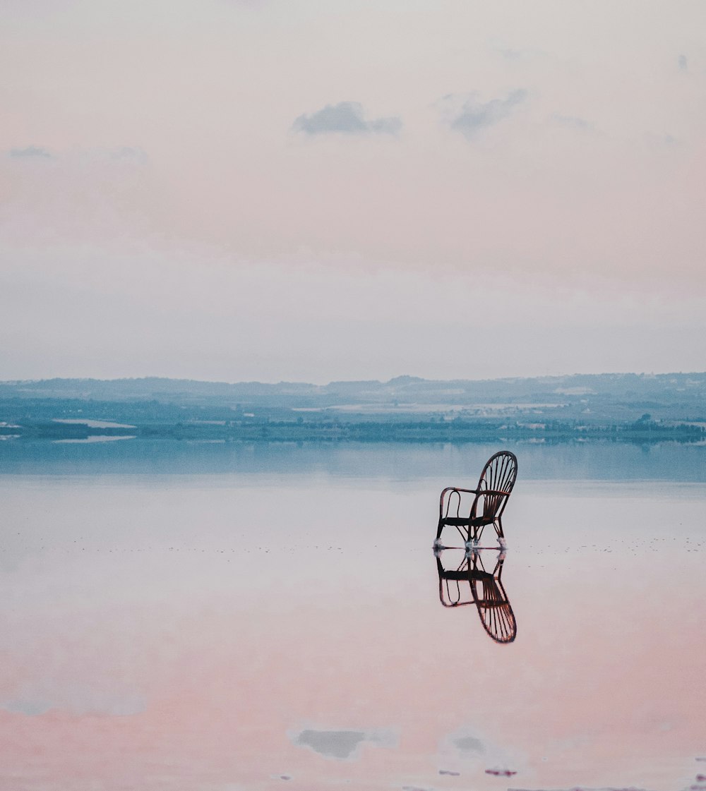 black metal chair on body of water during daytime
