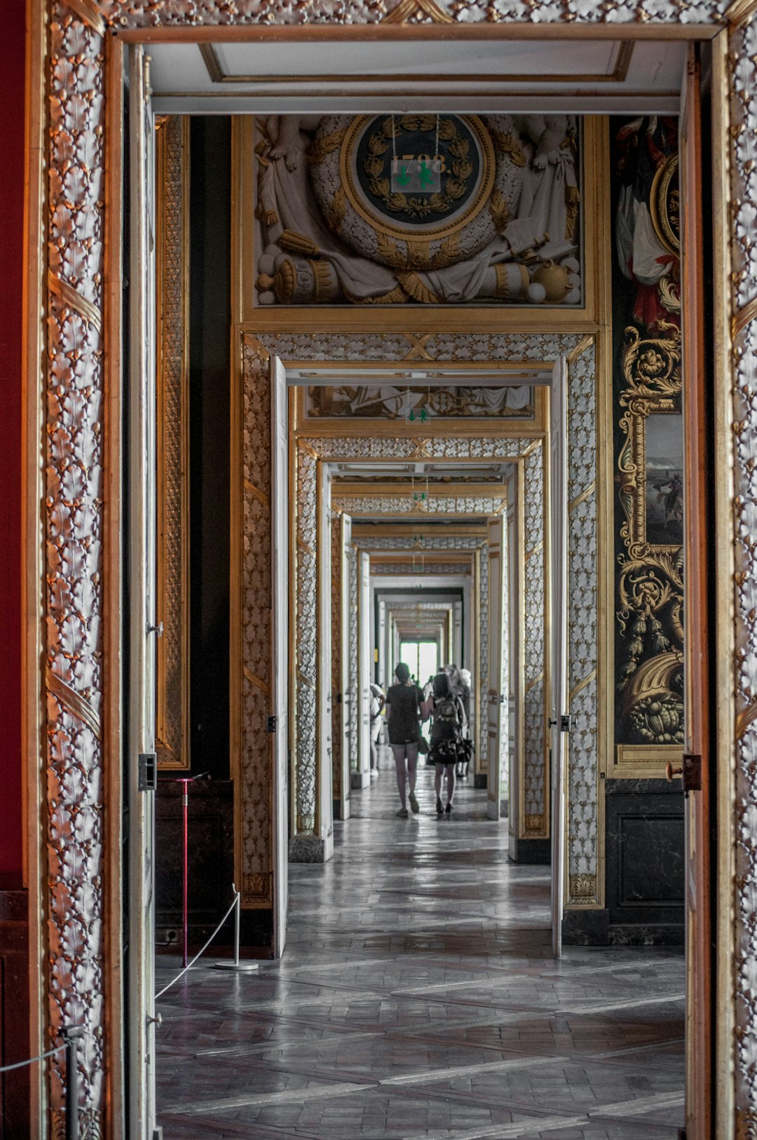 people walking on hallway with brown and red floral walls