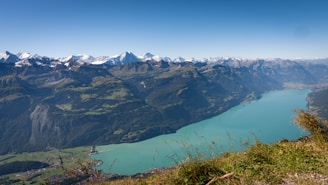 A panoramic view of the turquoise waters of Pangong Lake framed by snow-capped peaks.