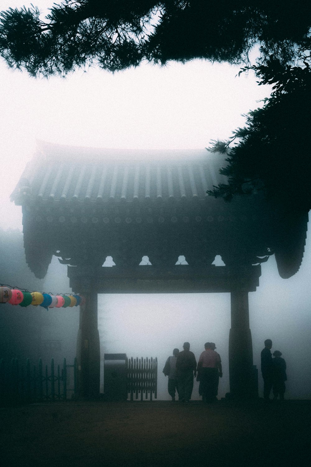 people standing near brown wooden gazebo during daytime