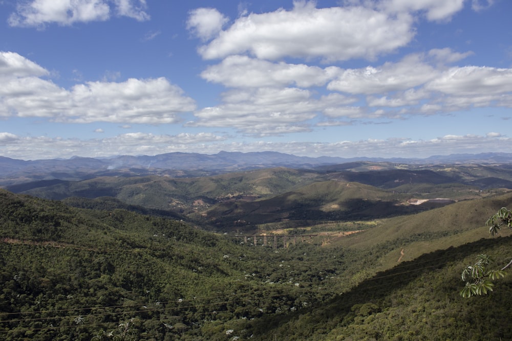 green mountains under blue sky and white clouds during daytime