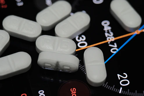 white medication pill on black and white remote control