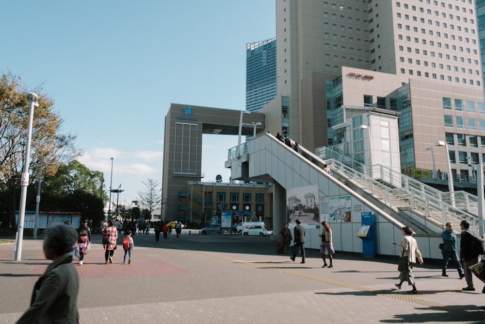 people walking on sidewalk near high rise building during daytime