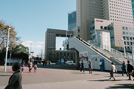 people walking on sidewalk near high rise building during daytime in Yokohama Japan