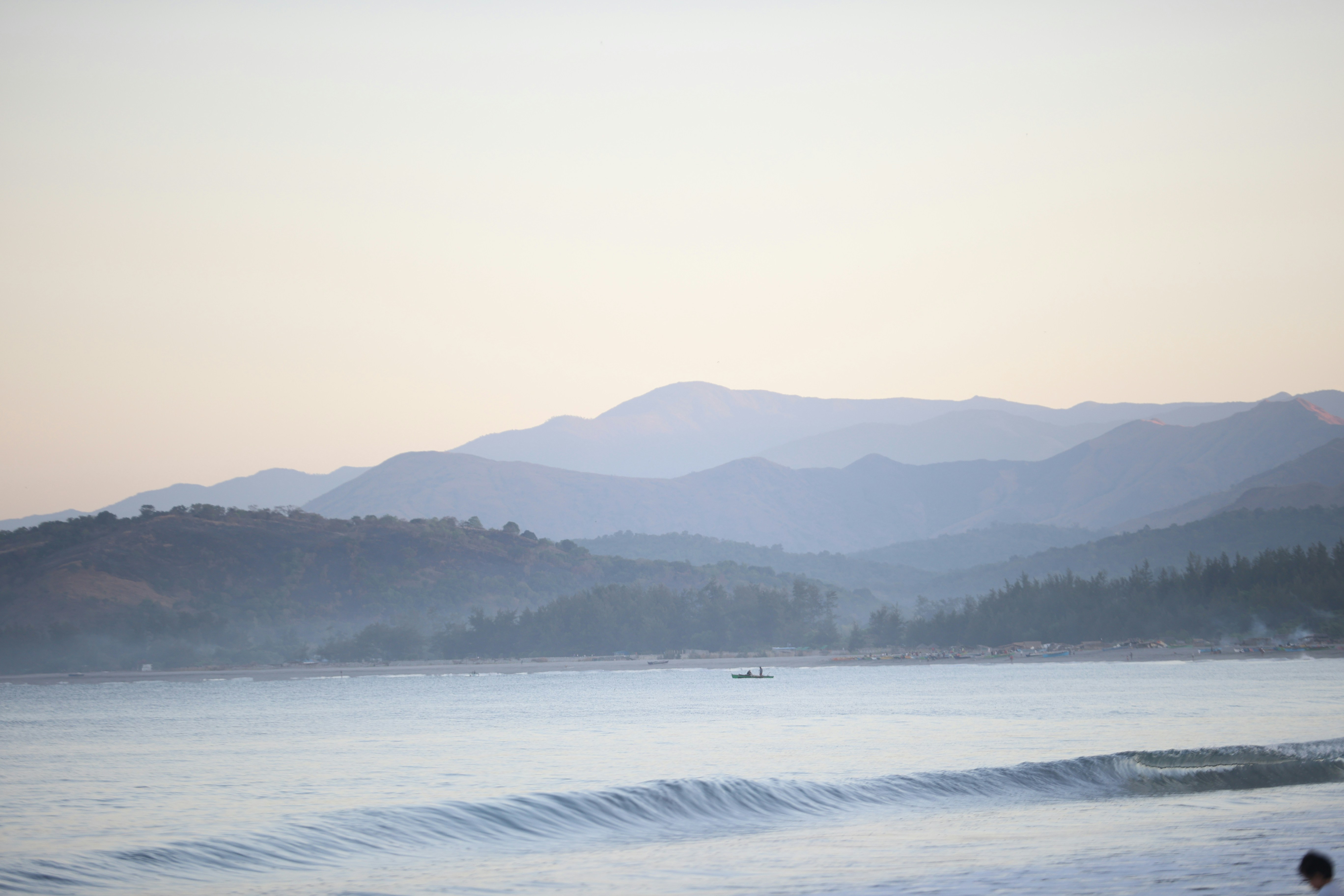 body of water near mountain during daytime