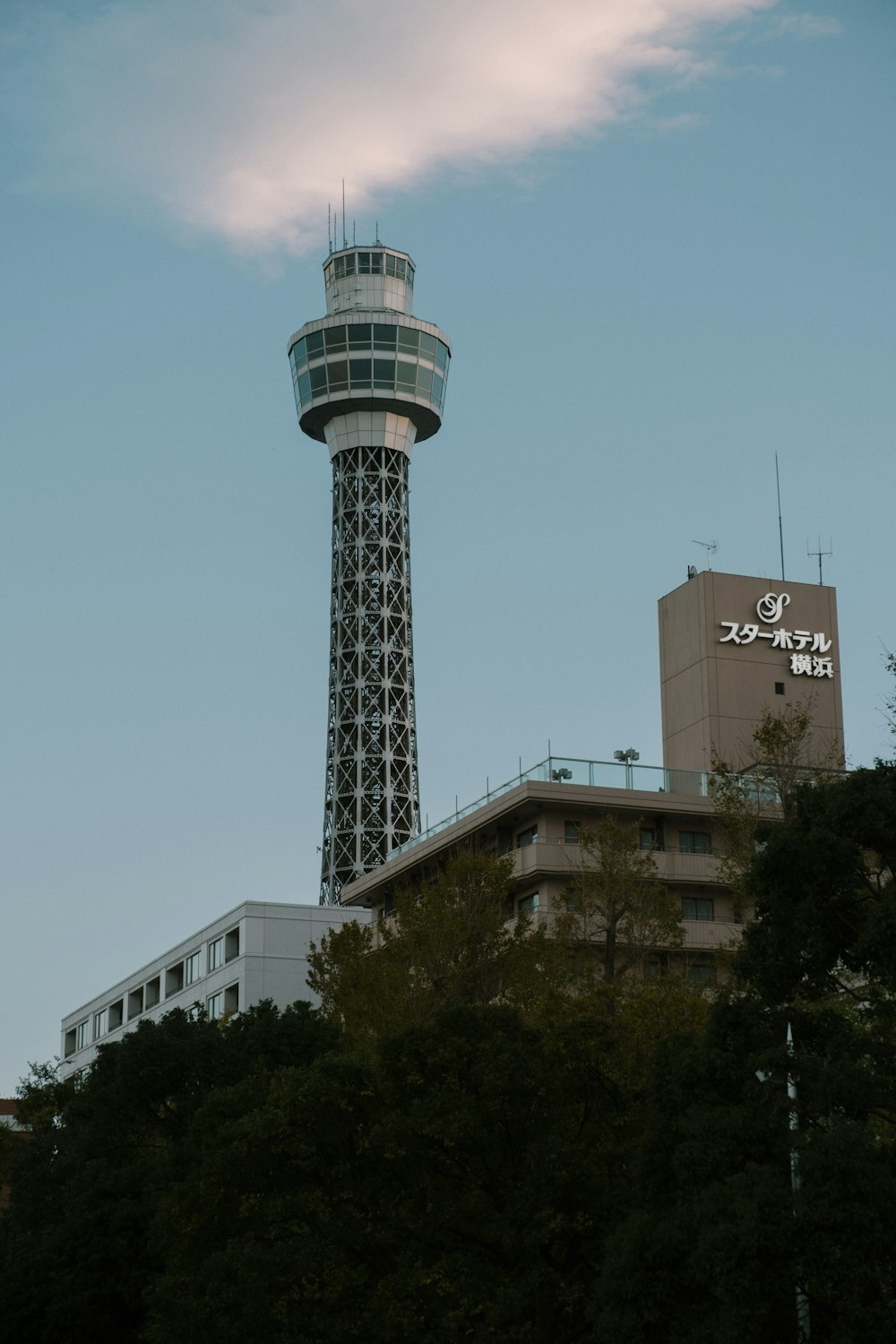 white and black tower near green trees during daytime