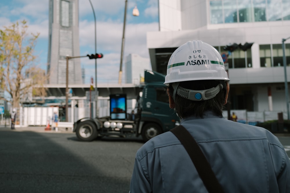 man in white hard hat and gray backpack standing on road during daytime