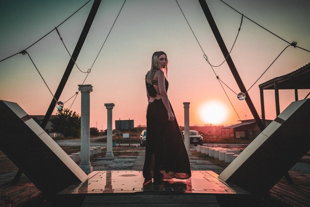 woman in black dress standing on brown brick floor during daytime