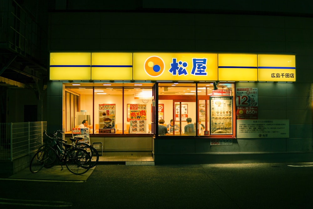 bicicleta da cidade preta estacionada ao lado da loja durante a noite