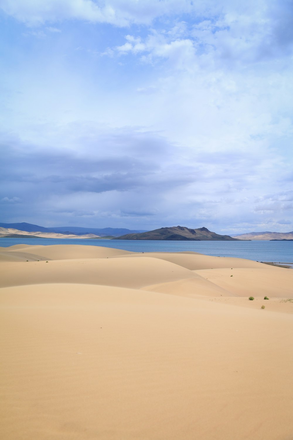 brown sand under white clouds during daytime