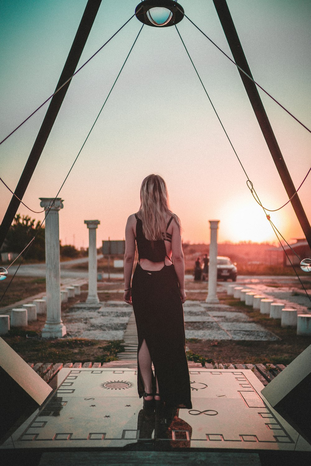 woman in black tank top and black leggings standing on brown concrete pavement during daytime