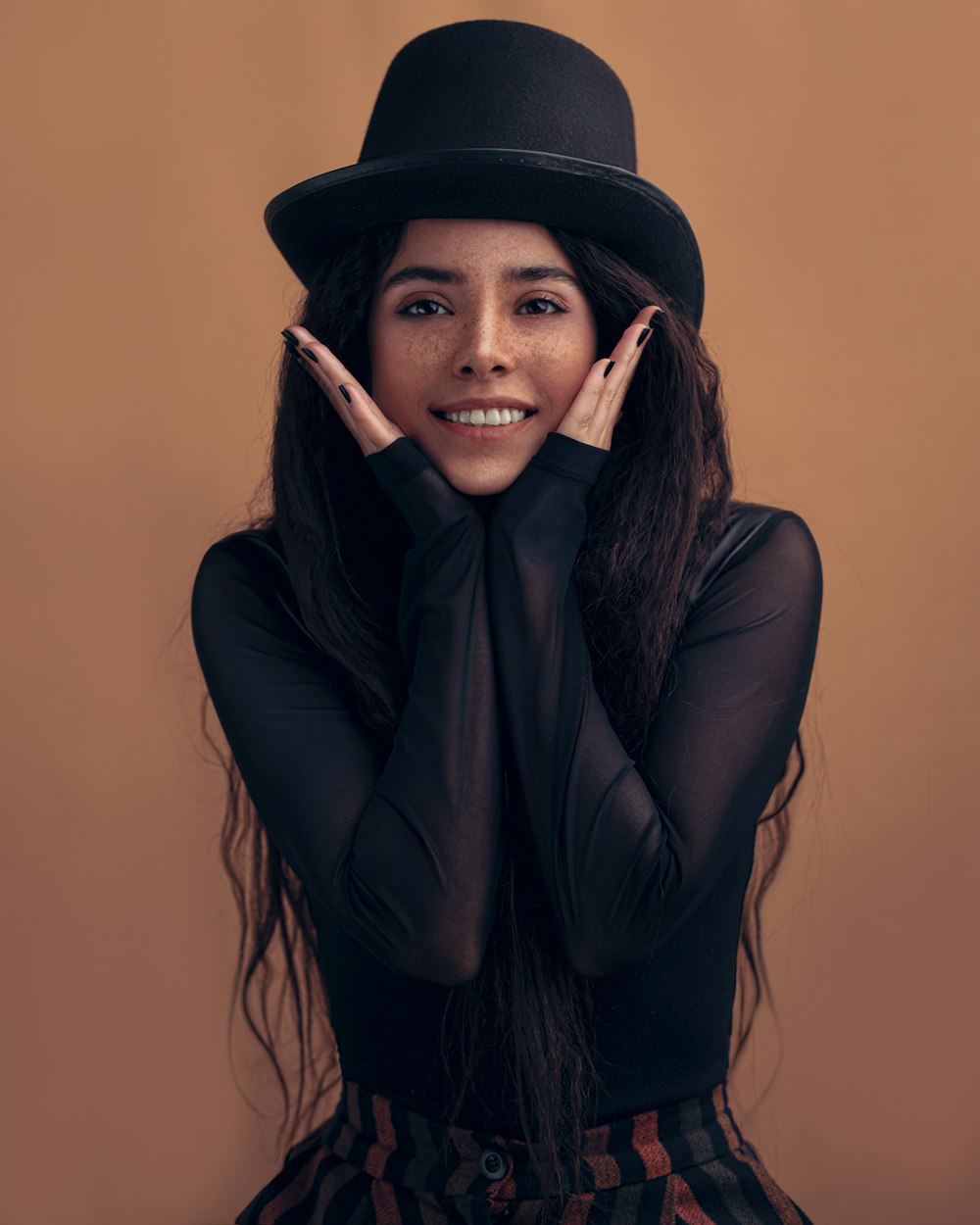 Frau in schwarzem Langarmhemd und schwarzem Hut