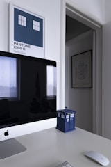 A minimalist office space with soft blue and cream tones, featuring a world map and shipping crates.