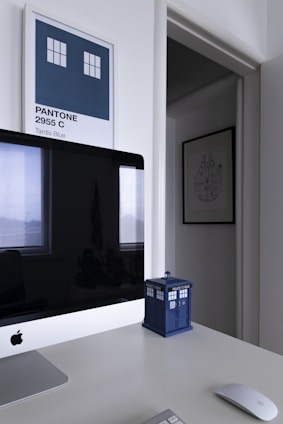 A minimalist office space with soft blue and cream tones, featuring a world map and shipping crates.