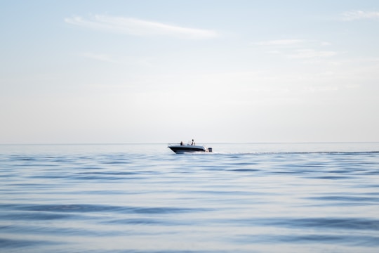 A modern rotomolded HDPE bowrider boat gliding smoothly on clear blue water under a sunny sky.