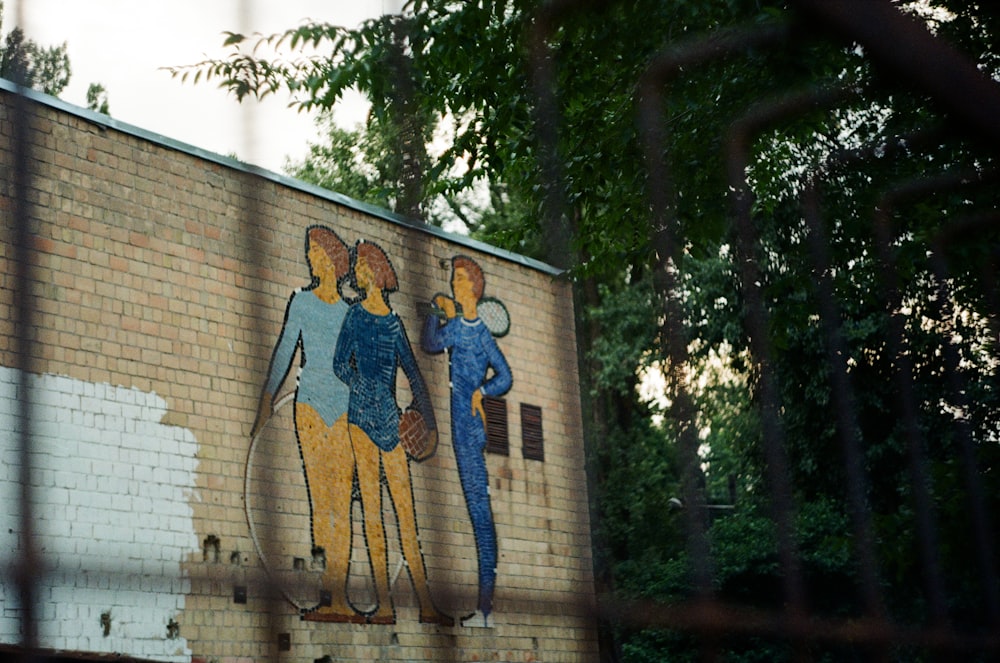 man in blue shirt and black pants standing beside woman in blue dress wall graffiti