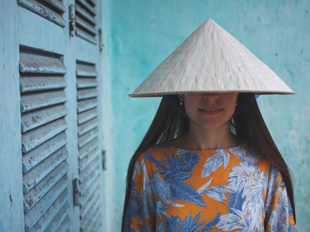 woman in blue orange and white floral shirt wearing white hat