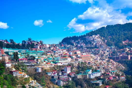 city near mountain under blue sky during daytime in Shimla India